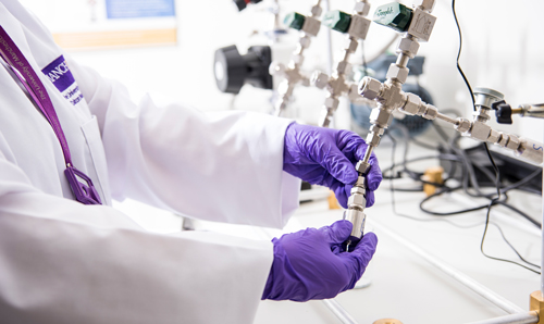 Anonymous hands adjusting machinery in laboratory